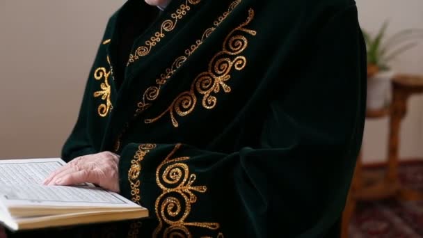 Un viejo mulá en traje nacional leyendo el Corán — Vídeo de stock