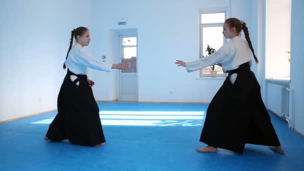 Två tjejer i svart hakama träna Aikido — Stockvideo