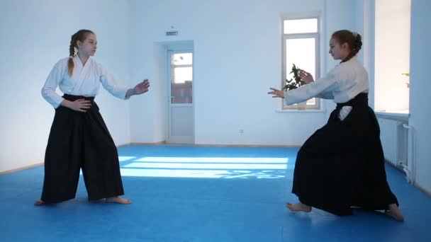 Dwie dziewczyny w czarnych hakama ćwiczyć Aikido — Wideo stockowe