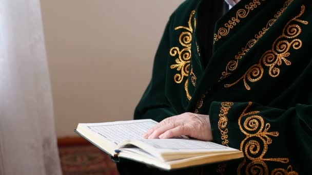 An old mullah in national dress reading the Koran — Stock Video