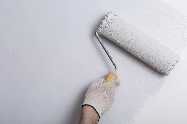 Zbliżenie na ramię malarz malowanie ścian z wałkiem — Zdjęcie stockowe