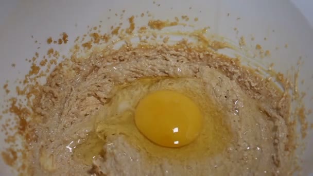 Putting eggs into a dough in a white bowl — Stock Video