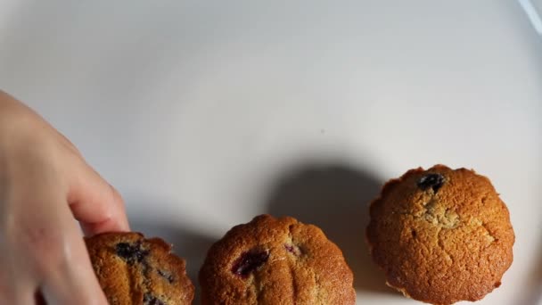 Vrouwelijke hand muffins serveren op een plaat — Stockvideo