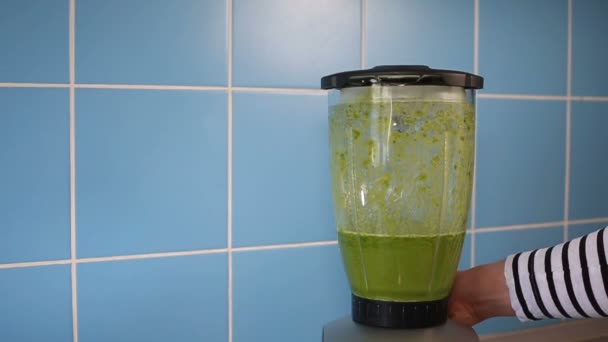 A blender jar with green healthy smoothie on blue — Stock Video