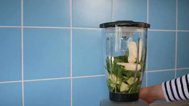 Hacer batido verde saludable en un frasco de vidrio en la licuadora en casa en la cocina — Vídeos de Stock