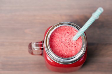 Ahşap arka plan üzerinde bir mason kavanoza karpuz güler yüzlü