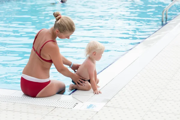 Madre e hijo se divierten junto a una piscina — Foto de Stock