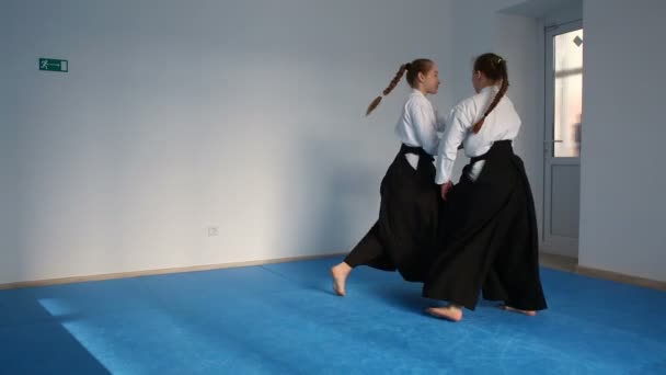 Dwie dziewczyny w czarnych hakama ćwiczyć Aikido — Wideo stockowe