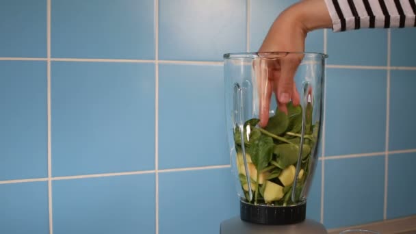 Κάνοντας πράσινο υγιεινό smoothie σε ένα γυάλινο βάζο στο μπλέντερ στο σπίτι στην κουζίνα — Αρχείο Βίντεο