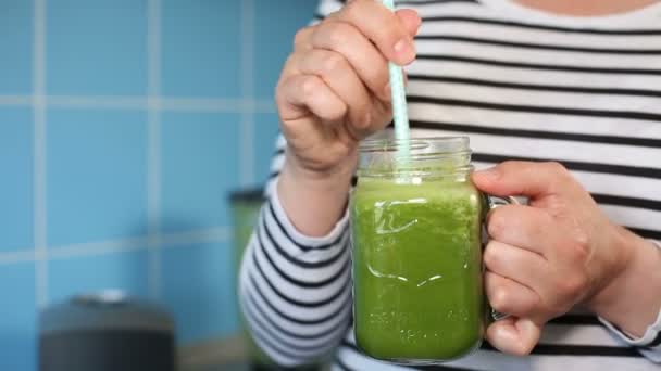 Degustación femenina de un batido verde — Vídeos de Stock