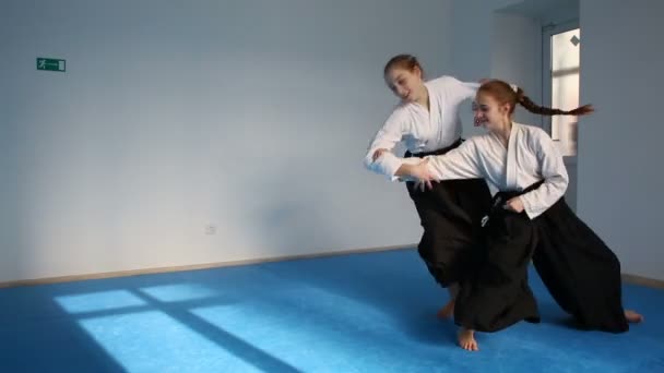 Twee meisjes in zwart hakama praktijk Aikido — Stockvideo
