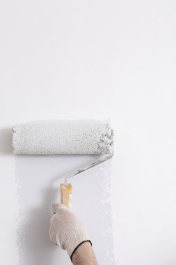 Bir duvar boya silindiri ile boyama ressam kolu yakın çekim