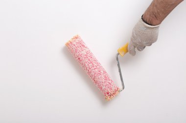 Kırmızı boya silindiri ile bir duvar boyama ressam kolu yakın çekim