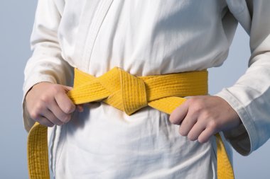 Bir genç üzerinde sarı kemer sıkma eller kimono giymiş