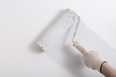 Bir duvar boya silindiri ile boyama ressam kolu yakın çekim