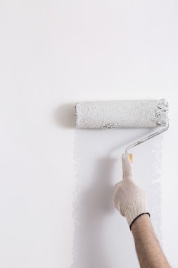 Bir duvar boya silindiri ile boyama ressam kolu yakın çekim