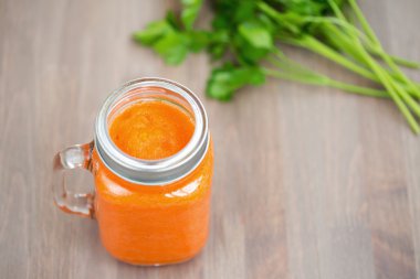 Tüp ahşap arka plan üzerinde bir kavanoza sağlıklı havuç güler yüzlü