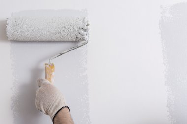 Bir duvar boya silindiri ile boyama ressam kolu yakın çekim