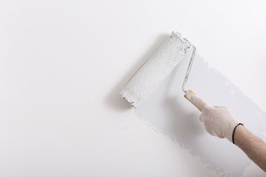 Bir duvar boya silindiri ile boyama ressam kolu yakın çekim