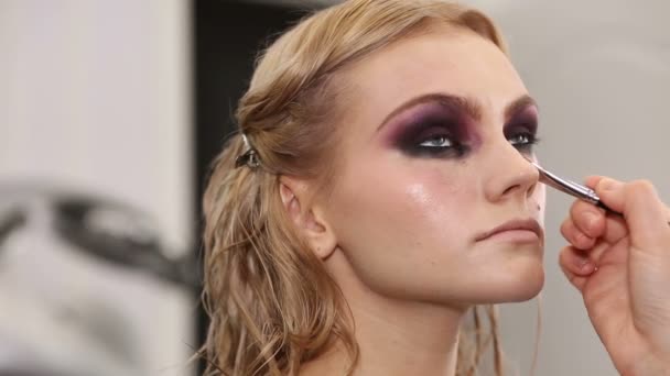 Artista de maquillaje profesional poniendo cosméticos en la cara del modelo — Vídeo de stock