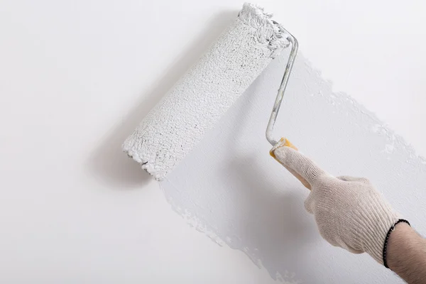 Bir duvar boya silindiri ile boyama ressam kolu yakın çekim