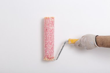 Kırmızı boya silindiri ile bir duvar boyama ressam kolu yakın çekim