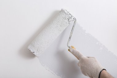 Bir duvar boya silindiri ile boyama ressam kolu yakın çekim