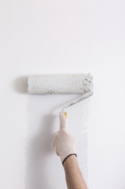 Bir duvar boya silindiri ile boyama ressam kolu yakın çekim