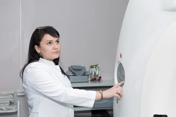 Una doctora presionando la tecla de control en el escáner CT — Foto de Stock