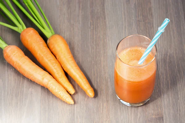 Friska morot smoothie i ett glas och råa morötter — Stockfoto