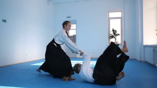 Dos chicas en hakama negro practican Aikido — Vídeo de stock