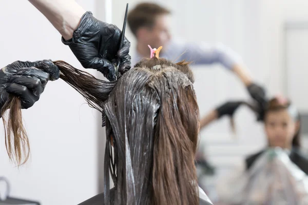 Een kapper kleuren haar voor een vrouwelijke client — Stockfoto