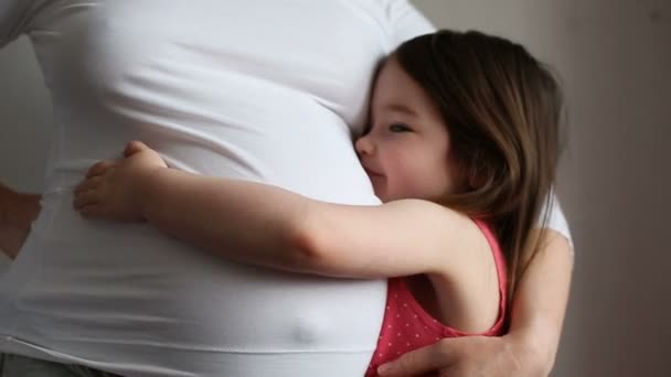 Маленькая девочка со своей беременной матерью — стоковое видео