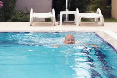 Sarışın bir çocuk yüzme öğrenme