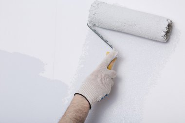 Bir duvar boya silindiri ile boyama ressam kolu yakın çekim