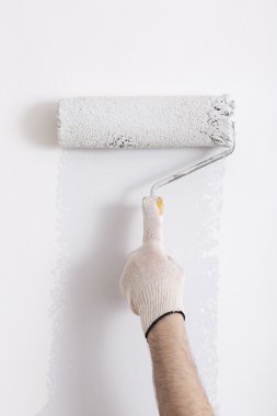 Bir duvar boya silindiri ile boyama ressam kolu yakın çekim