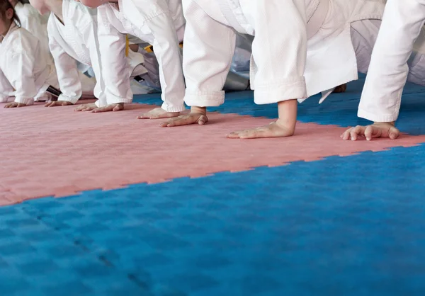 Gruppo di bambini in kimono push-up dal tatami sull'allenamento delle arti marziali — Foto Stock