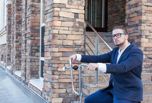 Um belo jovem empresário rolando sua bicicleta — Fotografia de Stock