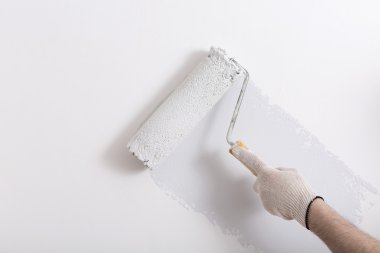 Close up of painter arm painting a wall with paint roller clipart