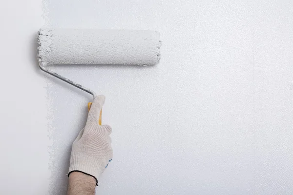 Primer plano del brazo del pintor pintando una pared con rodillo de pintura — Foto de Stock