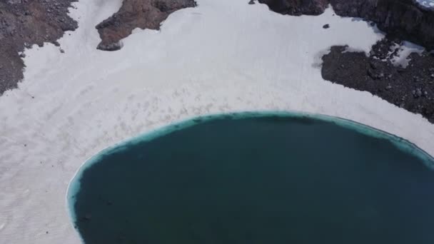 Volare all'indietro dal lago azzurro nel cratere del vulcano Gorely. Penisola di Kamchatka, Russia — Video Stock