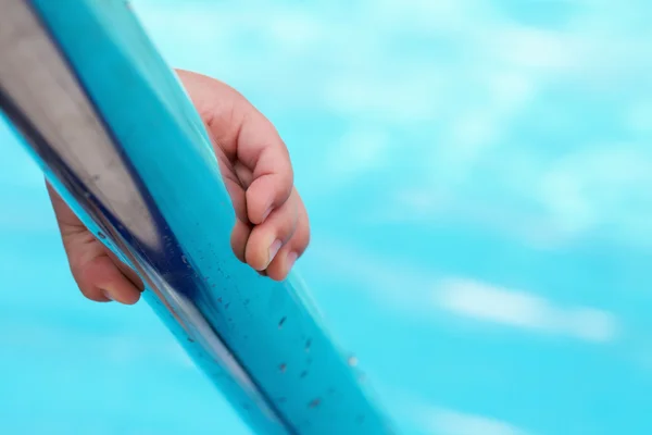 Childs mão segurando um corrimão na piscina — Fotografia de Stock