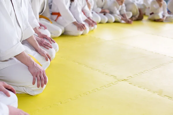 格闘技セミナーに畳の上に座って和服の人々 — ストック写真