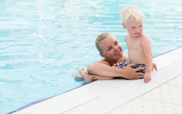 Madre e hijo se divierten junto a una piscina — Foto de Stock