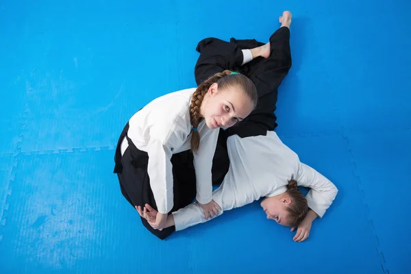 Två tjejer i svart hakama träna Aikido — Stockfoto