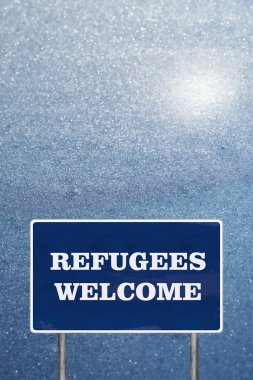 Mülteciler hoş geldiniz işareti ile yol işareti