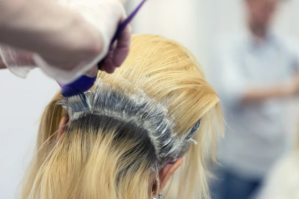 Ein Friseur bleicht Haare für eine blonde Kundin — Stockfoto