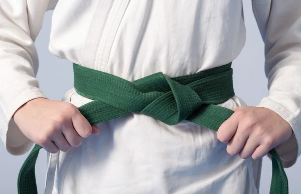 Hands tightening green belt on a teenage dressed in kimono — Stock Photo, Image