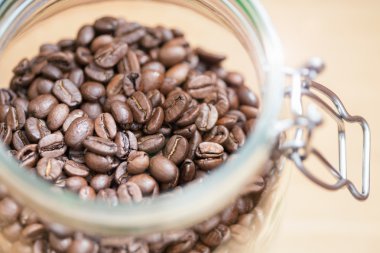 Kahve çekirdekleri bir cam kabın içinde. Sığ dof