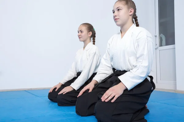 Two girls in hakama sitting on Aikido training — Stock Photo, Image